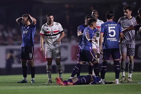 Juan Izquierdo: Juan Izquierdo of Uruguay's Nacional, bottom, lies on the pitch after collapsing during a Copa Libertadores soccer game